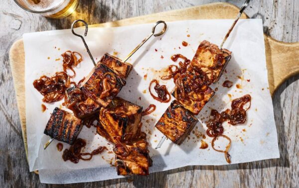 brochettes de tofu marinées vues de haut sur une planche en bois